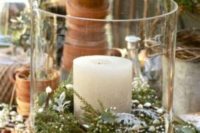 05 a large glass candle holder covered with burlap, with evergreens inside and a candle inside for a winter wedding