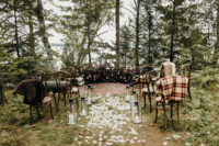 06 The ceremony space was done with a lush moody floral semi-circular arch and a boho rug, with lanterns and petals