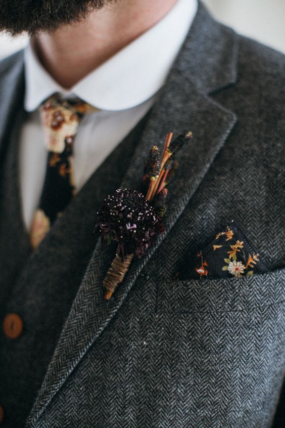a grey tweed three-piece wedding suit with a moody floral tie and handkerchief plus a herb boutonniere