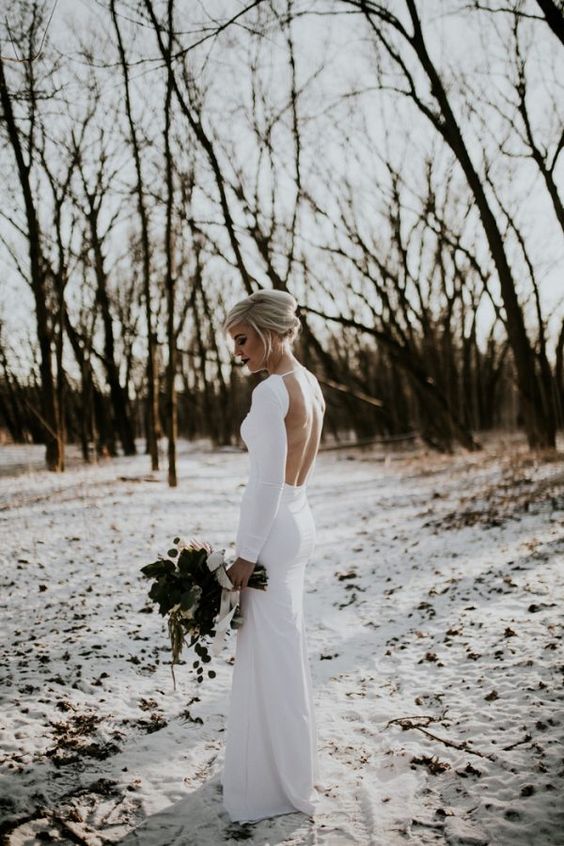 a minimalist fitting wedding gown with a high neckline and an open back for a stylish and sexy statement