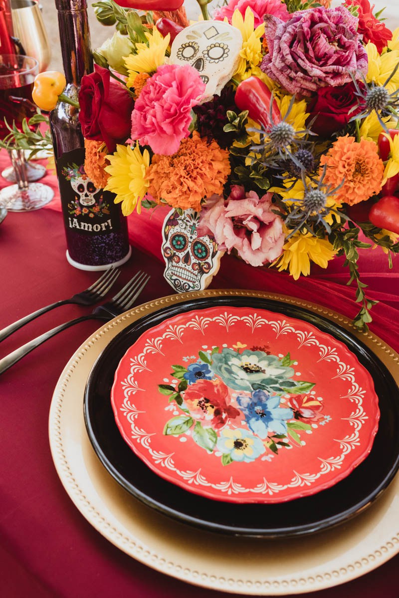 The wedding tablescape was done in black, red and gold, with sugar skulls, bright blooms