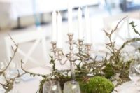 07 a simple and elegant Scandinavian wedding centerpiece of moss in a tin bowl, branches and a vintage candle holder