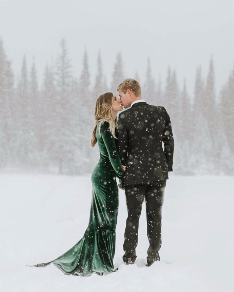 an emerald velvet fitting wedding dress with long sleeves and a train for a colorful touch