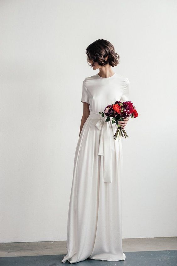 a modern wedding dress with a high neckline, short sleeves and a sash, no detailing at all