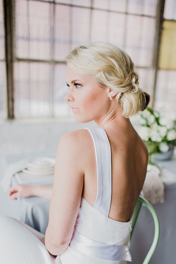 a simple low updo with waves is all you need for a simple and effortlessly chic bridal look, great for a modern bride