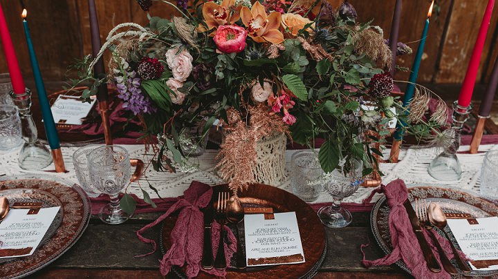 There was a macrame and colorful table runner, purple napkins, colorful candles and a luxurious moody centerpiece