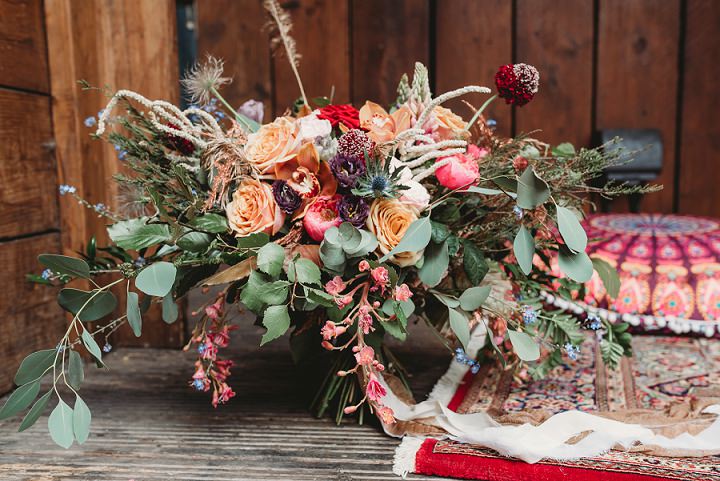 The wedding bouquet was a luxurious one with bold orange and burgundy blooms and lush foliage