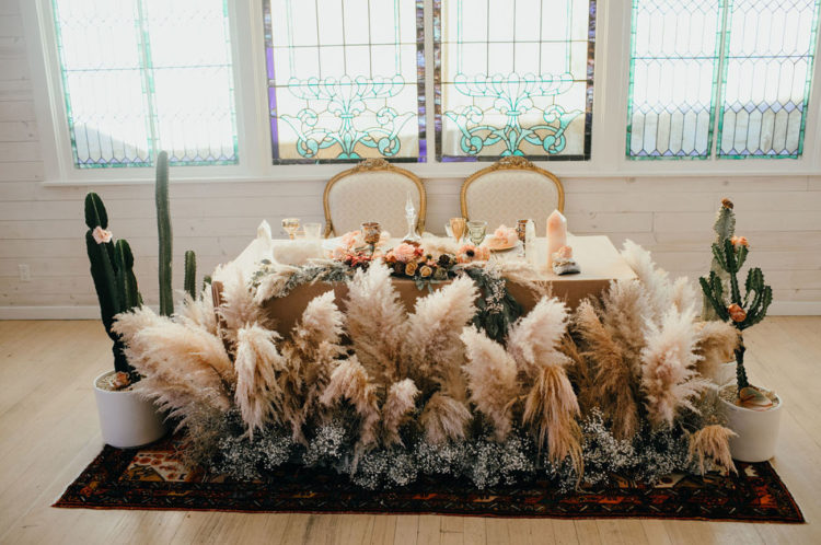 The wedding sweetheart table was surrounded with pampas grass and baby's breath plus cacti