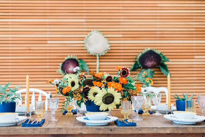 The wedding tablescape was a colorful one, with blue, red, ornage touches, colorful glasses and candles and potted cacti