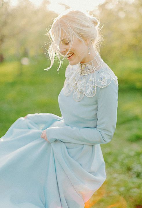 a blue wedding dress with an embellished neckline that features folksy motifs and long sleeves