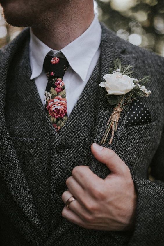 a grey three-piece wedding suit, a white sirt and a moody floral tie for a trendy winter groom look