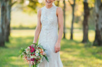 12 a fully embellished sleeveless wedding gown with a high neckline and a semi-sheer skirt for a glam bride