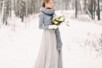 12 a grey wedding gown, a grey sweater over it, a grey chunky knit scarf and white mittens