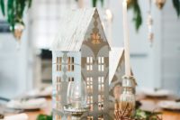14 a Nordic winter wedding centerpiece of ferns, dried herbs, antlers, candles and cardboard houses are a cool non-floral option