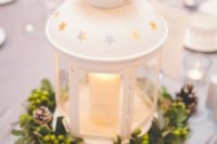 14 a white IKEA lantern centerpiece with a greenery wreath with berries and pinecones is ideal for Christmas
