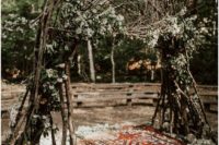 14 a wild wedding arch of branches, foliage, neutral blooms, rocks around and a boho carpet for a Nordic woodland ceremony