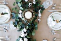 15 a chic and easy centerpiece of eucalyptus, cotton and a candle in a gilded candle holder for a winter Nordic wedding