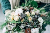 15 a winter Nordic wedding bouquet with evergreens, berries, cotton, pinecones and neutral blooms for a frozen touch