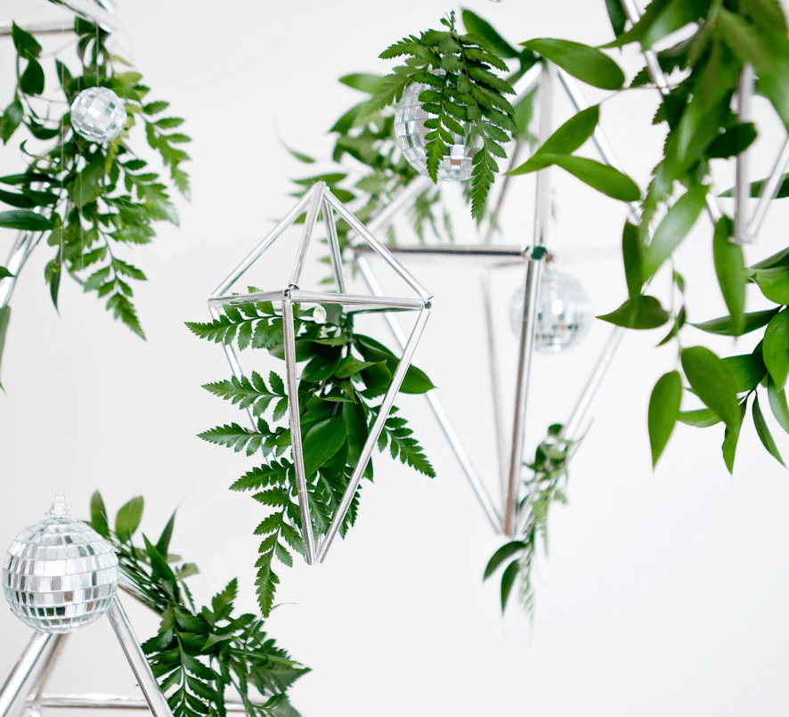 Silver diamonds and disco balls with greenery decor to create a modern and fresh backdrop or decor