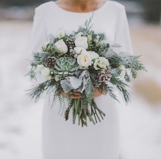 a grey and cream wedding bouquet with pale succulents, evergreens and pinecones for winter