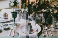16 a winter wedding tablescape with neutral napkins, black glasses, white floral centerpiece and black and white candles plus silver cutlery