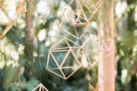16 hanging gold himmeli pendants and cascading greenery on the wedding arch make the ceremony space more modern and trendy