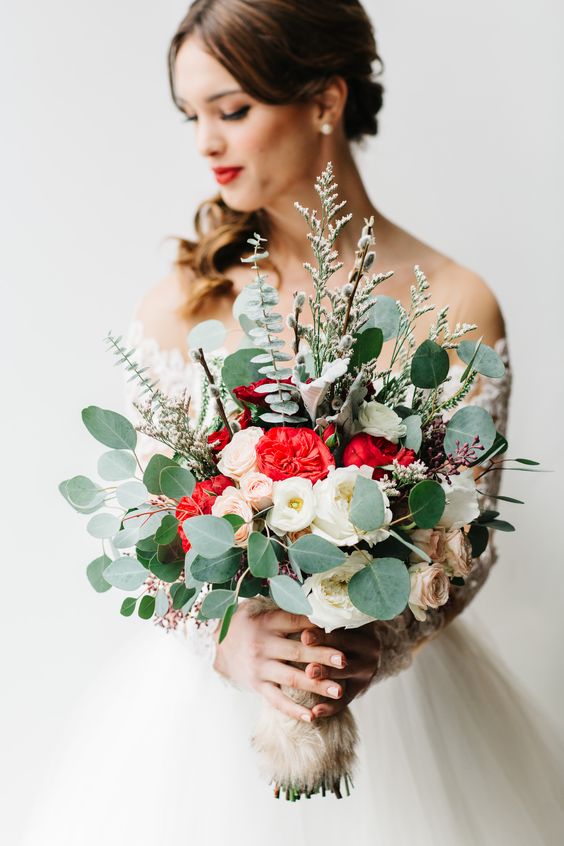 a Christmas wedding bouquet of eucalyptus, white, blush and red flowers plus herbs
