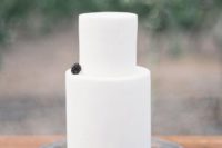 17 a pure white wedding cake topped with a single blackberry and displayed with greenery and blackberries for late summer