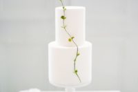 all-white minimalist wedding cake with a green touch