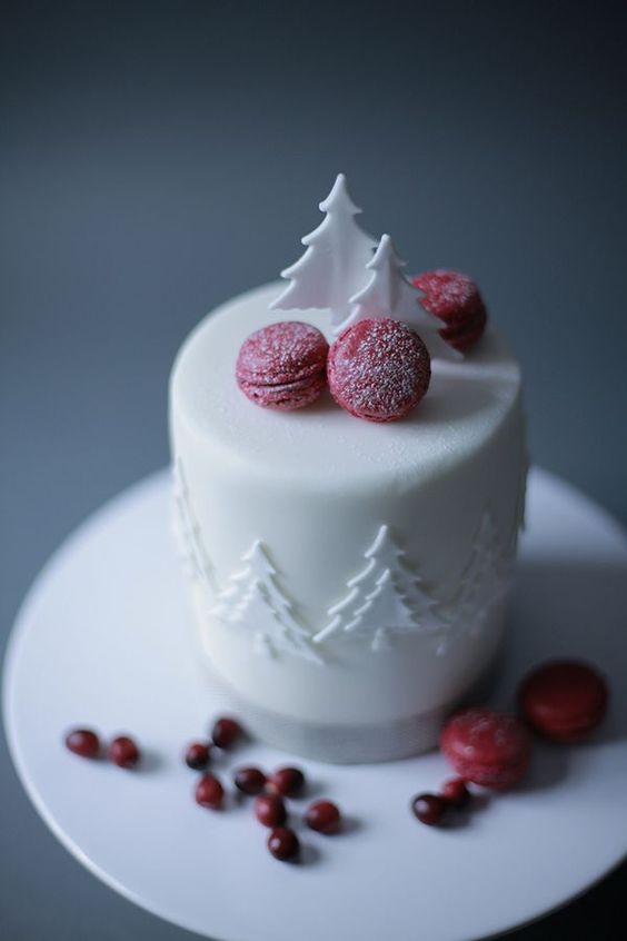 a white wedding cake with sugar trees and sugared cranberry macarons is a bright modern idea for Christmas