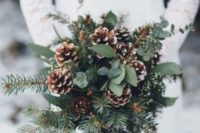 19 a cozy rustic winter wedding bouquet with evergreens, eucalyptus and snowy pinecones