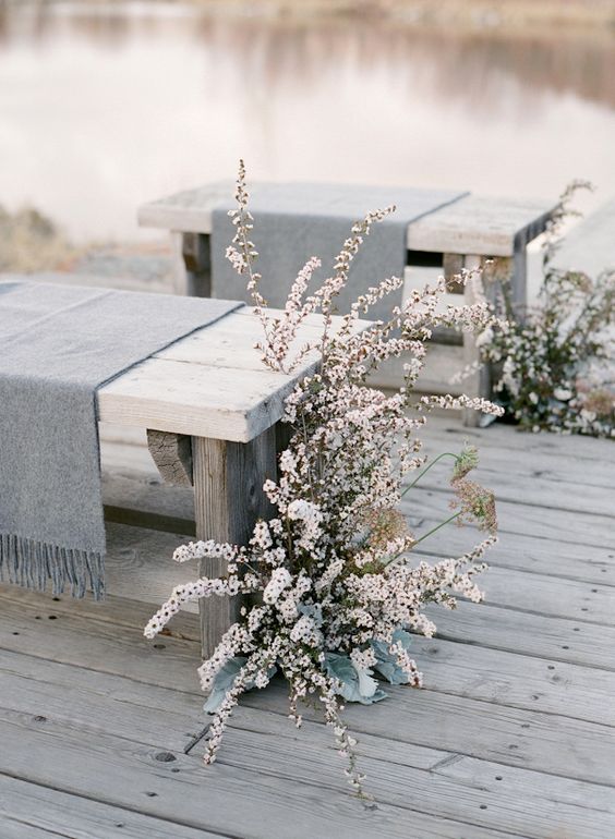 grey fringe throws on the benches plus white blooms for wedding aisle decor, so frozen-like