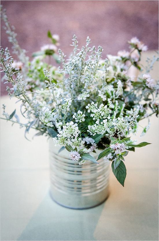 a rustic Scandinavian centerpiece of a tin can with wildflowers is great for a spring or summer wedding