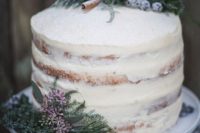21 a semi-naked winter wedding cake topped with evergreens, sugared berries, cinnamon sticks and blooms for a Nordic wedding