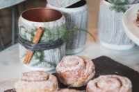 22 serve hot chocolate in copper mugs covered with knit, evergreens and cinnamon sticks and cinnamon buns to let guests feel cozy