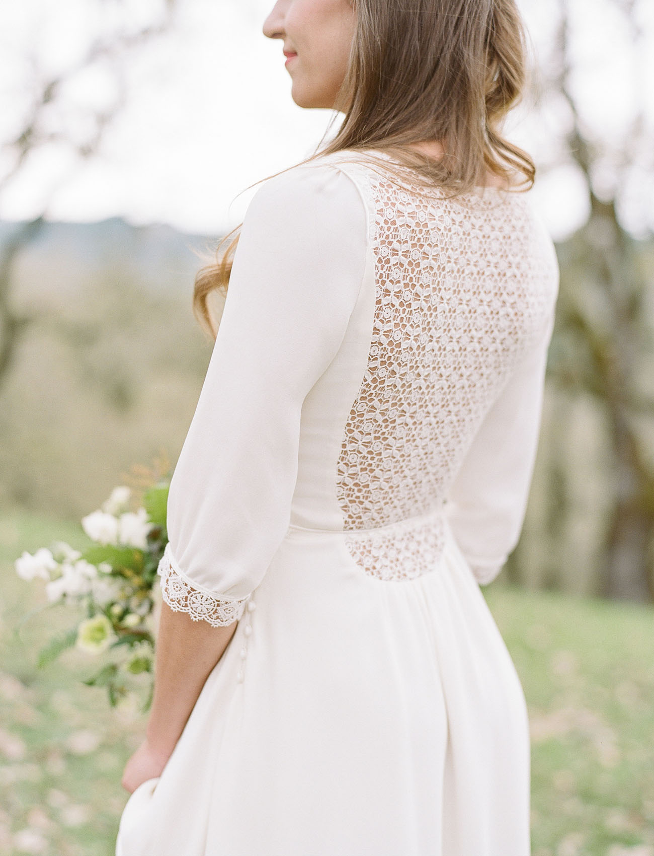 a plain wedding dress with a highlighted waist, long sleeves, a lace back and a lace trim on the sleeves for a romantic touch