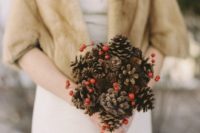 23 a simple Christmas wedding bouquet of pinecones and holly berries is a budget-friendly idea