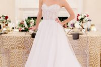24 a strapless A-line wedding dress with a fully embellished bodice and a layered skirt with a train