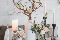 24 a subtle wedding centerpiece of white candles, blush roses and curly branches in matte white vases