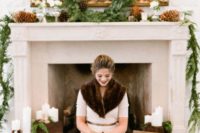 25 a cool winter fireplace decorated with evergreens and pinecones plus candles and a bride by it