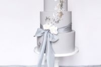 25 a dove grey wedding cake with a grey ribbon, white blooms and silver leaf decor for a trendy touch