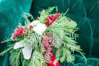 26 a textural wedding bouquet of evergreens, white blooms and berries plus red ribbons