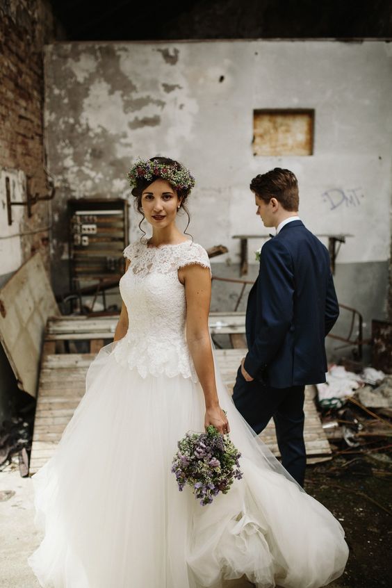 an A-line wedding dress with a lace bodice, cap sleeves, an illusion neckline and a layered tulle skirt
