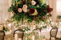 a bold and lush floral wedding centerpiece in blush, burgundy and green blooms and foliage of various shades