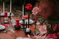 a chic wedding tablescape with pink and red roses and peonies, red and white candles, neutral plates and napkins