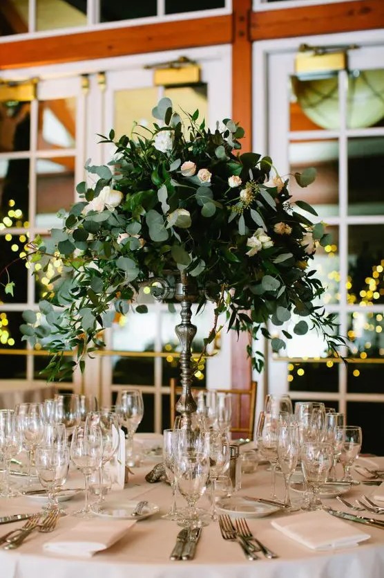 a eucalyptus and small blush roses centerpiece on a tall stand looks very elegant and chic