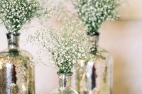 silver mercury glass vases with baby’s breath and matching candleholders are great for a glam and shiny wedding