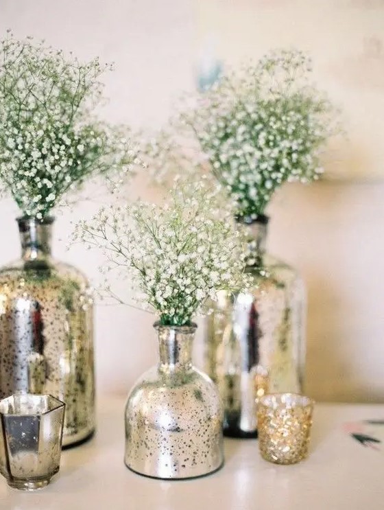 silver mercury glass vases with baby's breath and matching candleholders are great for a glam and shiny wedding