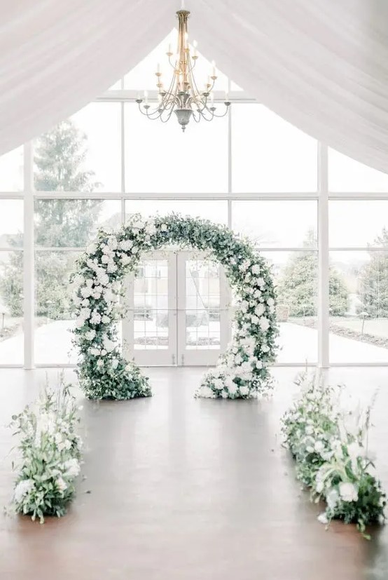 textural greenery and white blooms plus a matching round wedding arch for creating a romantic and beautiful winter wedding space