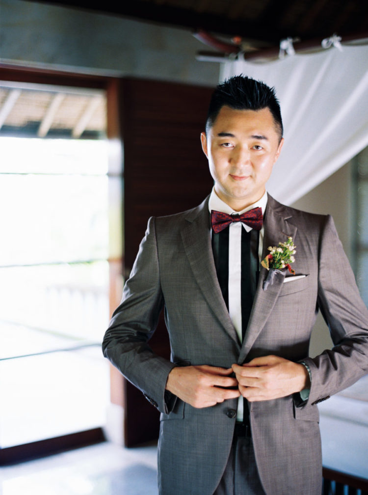The groom was wearing a grey suit, a striped shirt and a burgundy bow tie